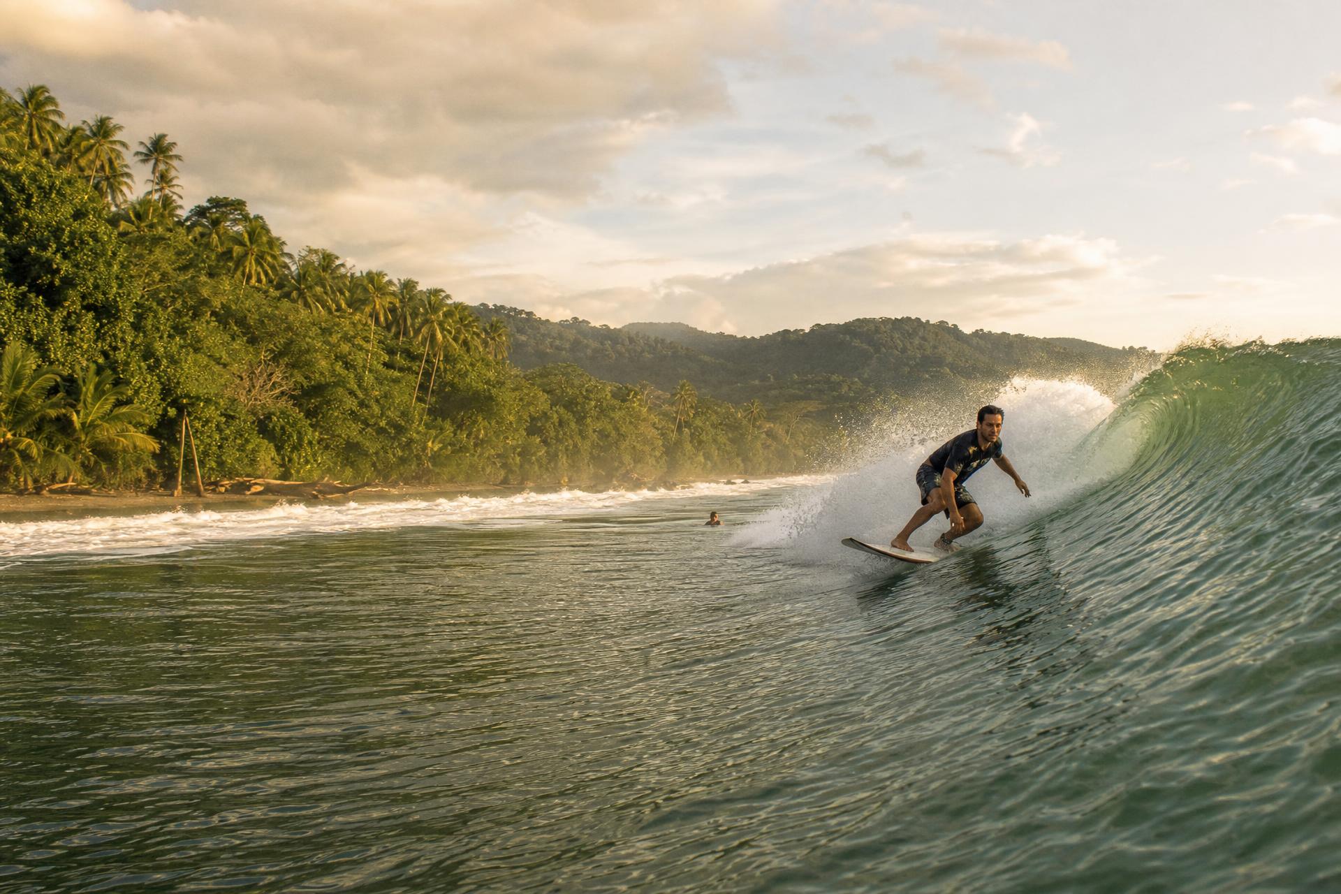 A long left-hand point break peeling along the jungle coastline of Pavones, Costa Rica